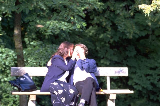 Pareja bes�ndose en un banco